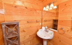 a wooden bathroom with a sink and a mirror at Bearfoot Lodge in Gatlinburg +25 photos