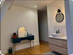 ein Badezimmer mit Waschbecken und Spiegel in der Unterkunft Villa Petit Prince - Logement entier in La Celle-sous-Gouzon