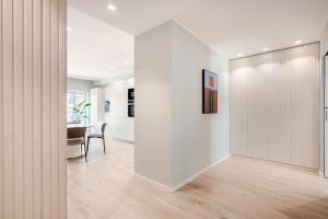 a hallway with white walls and a dining room with a table at Argiro Apartment by Palazzo Zippitelli in Bari