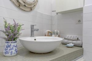 Un baño con un lavabo y un jarrón con flores. en Delizioso attico con terrazzo, en Roma 8 fotos más