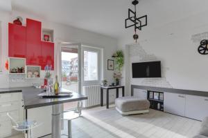 cocina con armarios rojos y blancos y TV en Delizioso attico con terrazzo, en Roma