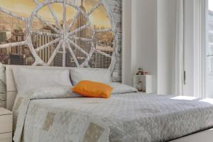 Dormitorio con cama con almohada naranja en Delizioso attico con terrazzo, en Roma