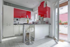 cocina con armarios rojos y encimera en Delizioso attico con terrazzo, en Roma