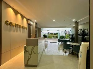 a lobby with a restaurant with a table and chairs at Golden Sun Hotel 5 - Quận 2 in Ho Chi Minh City