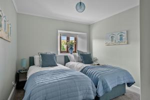 a bedroom with two beds and a window at The Hayloft in Dittisham