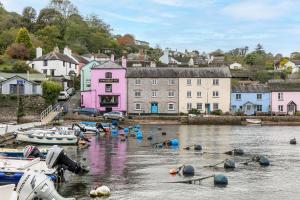 a group of boats in the water near a town at The Hayloft in Dittisham