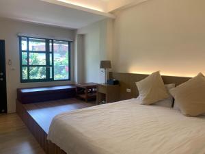 Una cama o camas en una habitación de Jiang's B&B 江院子庭園民宿