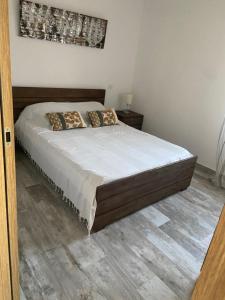 a bed in a bedroom with a wooden floor at Appartement F3 Algajola les pieds dans l eau in Aregno