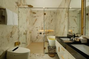 a bathroom with a toilet and a sink and a shower at Villa Kalem Uluwatu by Nakula in Uluwatu