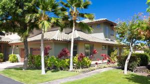 ワイコロアにあるMakai Living Fresh 2BR Fairways Home Near Rec Centerの前にヤシの木がある家