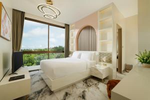 a bedroom with a large white bed and a large window at Villa Kalem Uluwatu by Nakula in Uluwatu +20 photos