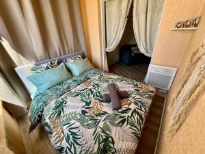 a small bedroom with a bed with a tropical print at Evasion cosy aux pieds de l'Océan in Lacanau