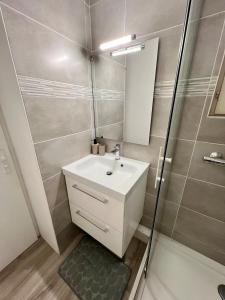 a bathroom with a white sink and a shower at Evasion cosy aux pieds de l'Océan in Lacanau +18 photos