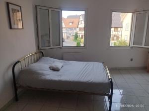 a bed in a room with two windows at Canal4 in Eckbolsheim