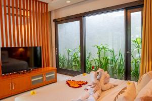 un bambino sdraiato su un letto davanti alla TV di Jineng Febe G Villa a Seminyak