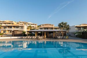 a swimming pool in front of a hotel at Grand Blue Beach Hotel in Kardamaina