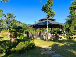 a gazebo in a park with a tree at Kim Hoa Villa in Ðồng Gội