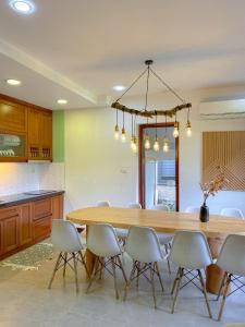 a dining room with a wooden table and chairs at Kim Hoa Villa in Ðồng Gội