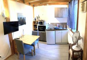 a small kitchen with a table and a kitchen with a stove at Studio Mezza in Chambéry