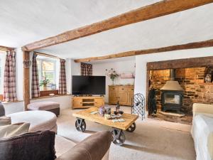 a living room with a tv and a fireplace at 2 Pigsfoot Cottages in Tiverton