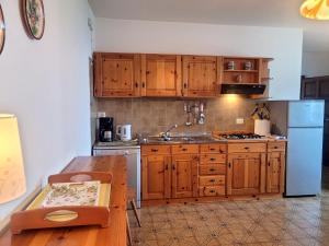 a kitchen with wooden cabinets and a table and a refrigerator at Vento Blu in Domaso