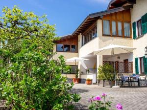 a house with tables and umbrellas in front of it at Vento Blu in Domaso +22 photos