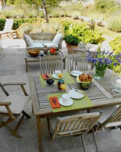 a wooden table and chairs on a patio with a table and chairs at Appartement charmant à Seillans avec piscine in Seillans +5 photos