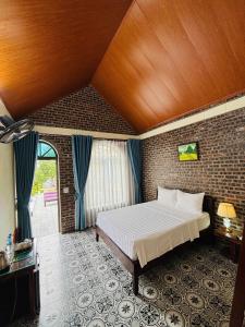a bedroom with a large bed with a wooden ceiling at Tam Coc Pomelo Garden in Ninh Binh