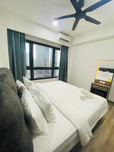 a bedroom with a white bed with a ceiling fan at Homestay Agile At Bukit Bintang KL in Kuala Lumpur