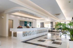 a lobby with a reception counter and plants at Grand Blue Beach Hotel in Kardamaina +77 photos