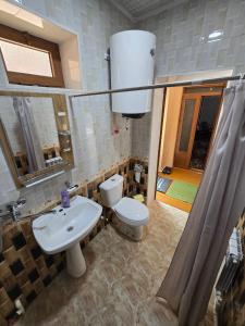 Un baño con un inodoro blanco y un lavabo. en Sezam, en Bukhara