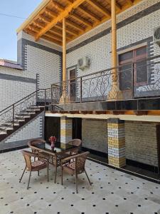 patio con mesa y sillas y balcón en Sezam, en Bukhara