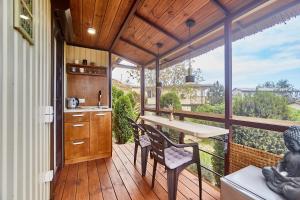 a kitchen with a table and chairs on a deck at Отдых у моря in Nova Dofinivka