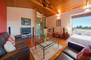 sala de estar con sofá y cama en Mapua Hills Studio Bed and Breakfast, en Mapua