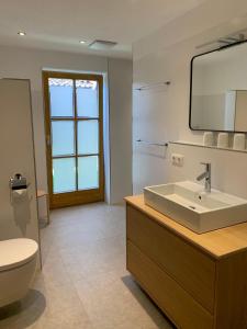 a bathroom with a sink and a toilet and a mirror at Ferienhaus Pfeiffer in Schwangau +15 photos