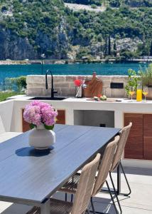 a kitchen table with a vase of flowers on it at Pool 4 Leisure Dubrovnik in Dubrovnik