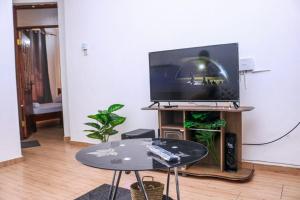 a living room with a table and a tv at CASEY APARTMENT ,2Mins TO JCC BAMBURI MTAMBO in Mombasa