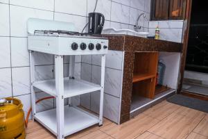 a kitchen with a white stove and a sink at CASEY APARTMENT ,2Mins TO JCC BAMBURI MTAMBO in Mombasa