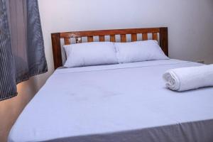 a bedroom with two beds with white sheets at CASEY APARTMENT ,2Mins TO JCC BAMBURI MTAMBO in Mombasa