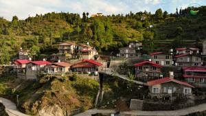 a village on a hill with houses on it at Indus Valley Homestay in Mukteswar