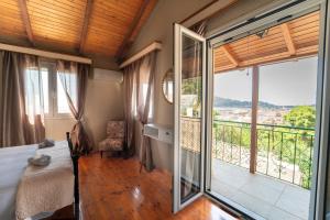 a bedroom with a bed and a large window at Popolaros Traditional House in Zakynthos