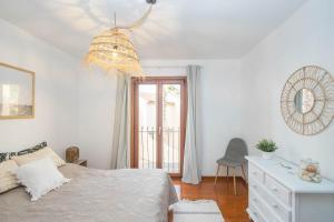 a bedroom with a bed and a desk and a chandelier at Lightbooking Paraiso Fuerteventura con piscina in Parque Holandes +14 photos