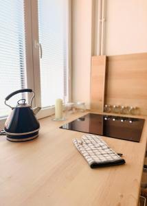 a tea kettle and a keyboard on a wooden desk at Srdce Mesta 2 - smart apartmán Pod Lipou v centre in Gerlachov