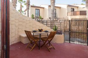 a table and two chairs on a patio at Lightbooking Paraiso Fuerteventura con piscina in Parque Holandes