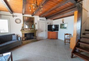 a living room with a fireplace and a couch at Popolaros Traditional House in Zakynthos