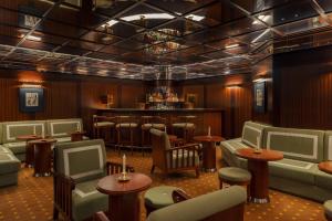 a bar with chairs and tables in a room at Hôtel Des Grands Voyageurs in Paris