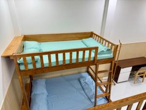 two bunk beds in a room with blue pillows at Nhà Nghỉ Phố Biển Phan Thiết in Ấp Bình Hưng