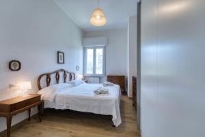 Schlafzimmer mit einem weißen Bett und einem Holztisch in der Unterkunft Casella - Boutique Home in Florence in Florenz