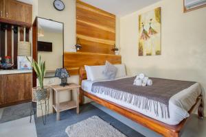 a bedroom with a large bed and a mirror at Central Cozy Bungalow 2 with AC and WIFI 5 min to Beach in General Luna