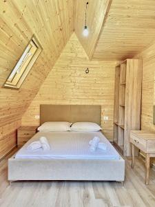 Un dormitorio con una cama en una habitación de madera. en Sea Wood Villas, en Golem